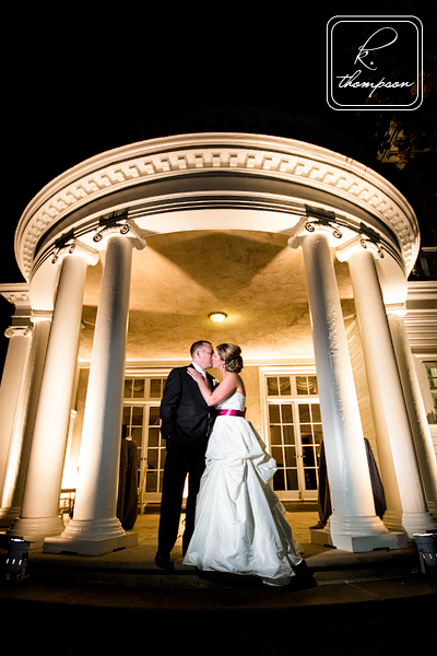 Bride and groom under portico at Woodened sanctuary at night